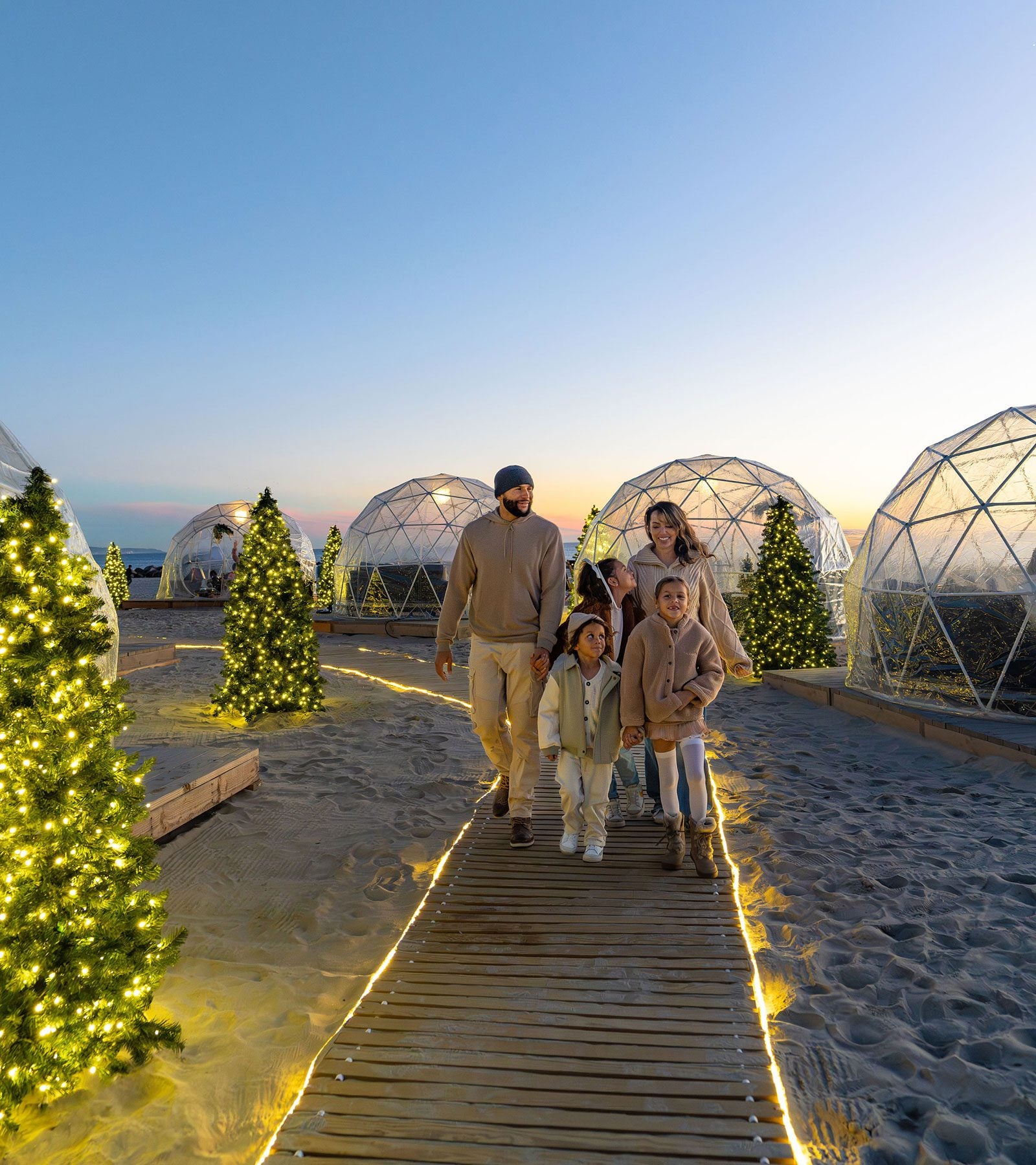 Family walking near beach igloos